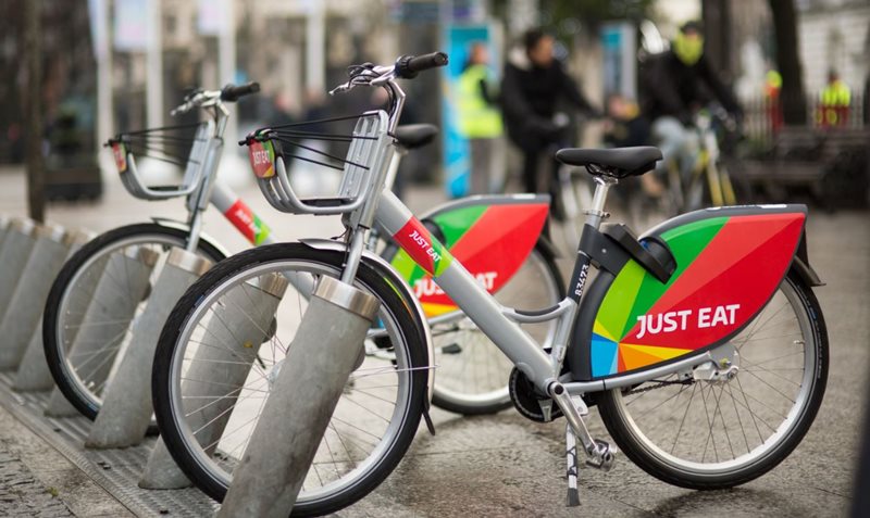 Just Eat Belfast Bikes parked at a docking station.