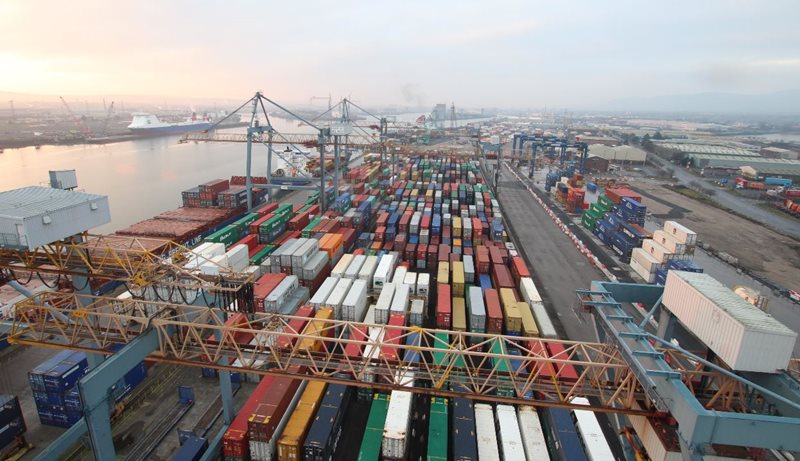 Aerial view of shipping containers, cranes and docks in Belfast Harbour, looking towards Belfast Lough.